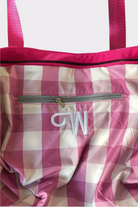 The Urban Slate Waterproof Bag is a pink and white checkered gym and travel bag with a pink zipper, pink handles, an inner zip pocket, and “CW” embroidered in white—perfect as a stylish duffel for your essentials.